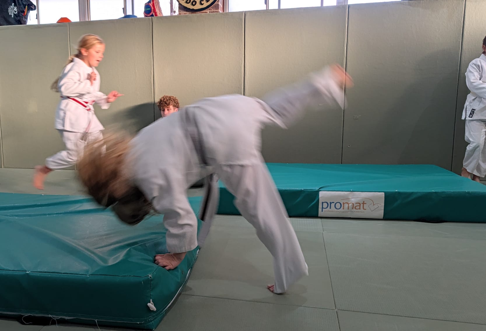 Young Ely Dojo members safely practising judo movement on the mats
